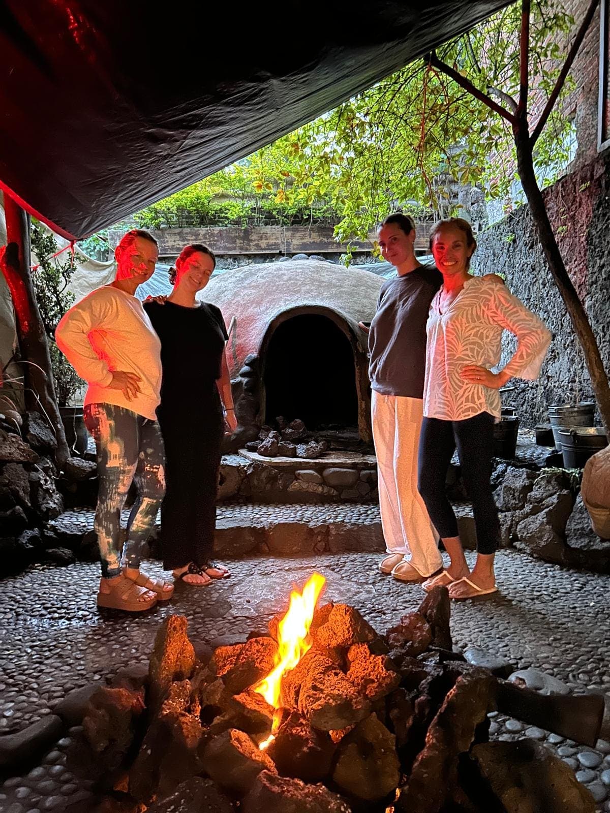 Retreat guests gathered around the fire at the temazcal